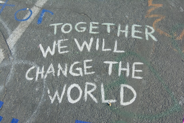 Together we will change the world written on the pavement with chalk